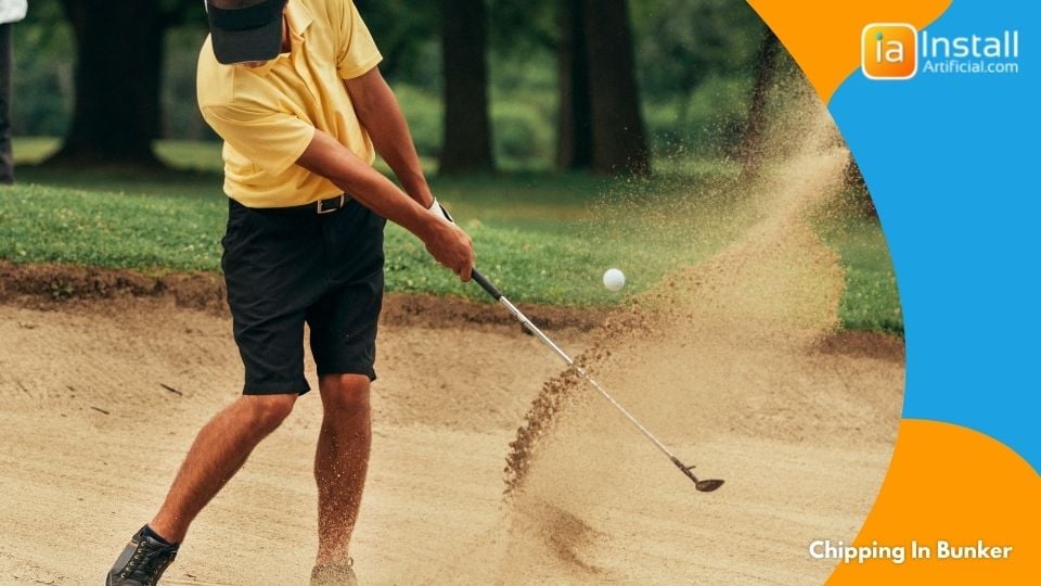 chipping in sand bunker to practice swing on putting green