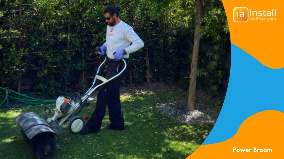 power brushing grass blades after artificial turf installation in backyard.